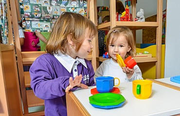 Mädchen freuen sich über die Ausstattung der Puppenküche